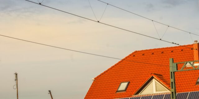 Orange roof with solar panels and overhead wires